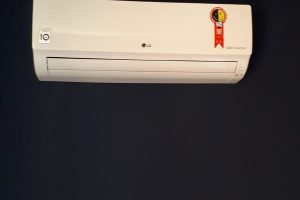 Unidade de ar-condicionado LG Dual Inverter montada em uma parede escura.